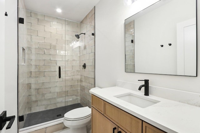 bathroom featuring vanity, toilet, and a shower with door