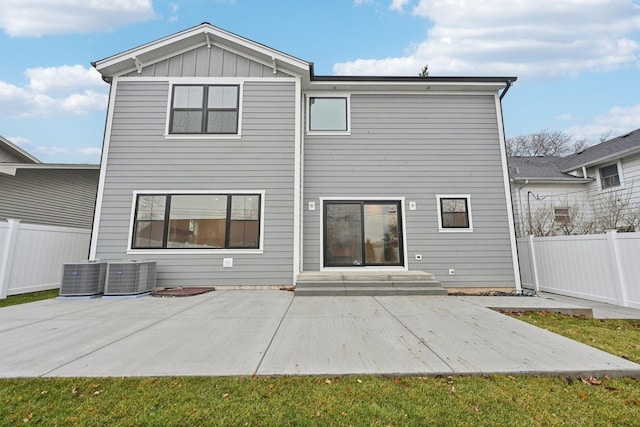 rear view of house featuring cooling unit, a yard, and a patio