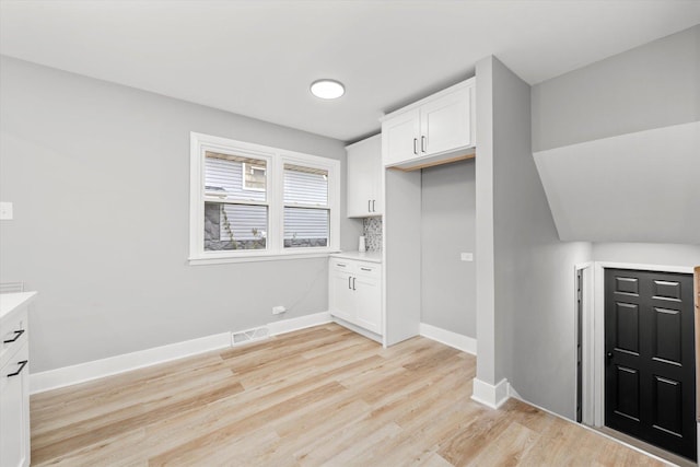 kitchen with light hardwood / wood-style floors and white cabinetry