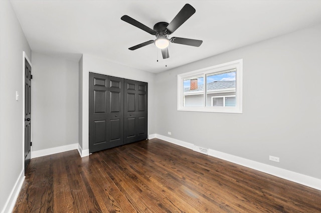 unfurnished bedroom with ceiling fan, dark hardwood / wood-style floors, and a closet