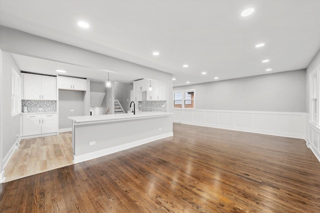 unfurnished living room with sink and light wood-type flooring