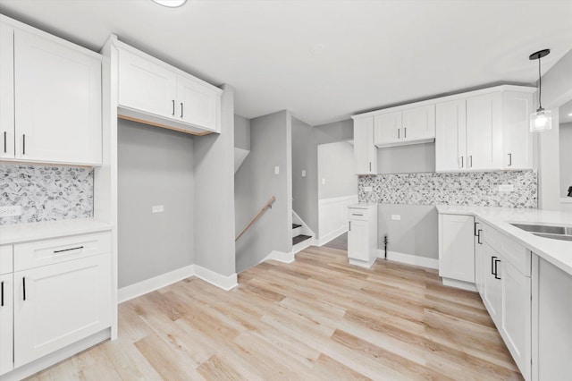 kitchen featuring sink, pendant lighting, decorative backsplash, and white cabinetry