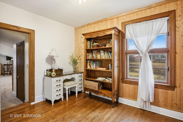 interior space with hardwood / wood-style floors and wood walls