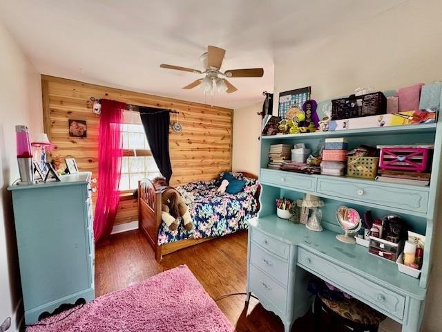 bedroom with dark hardwood / wood-style flooring and ceiling fan