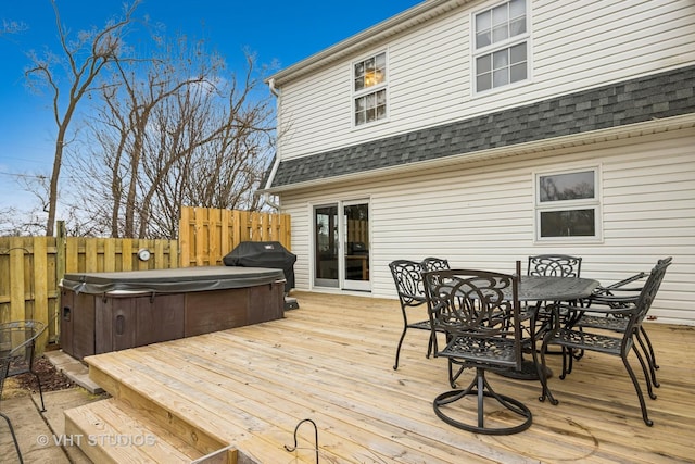 wooden deck featuring a hot tub and a grill