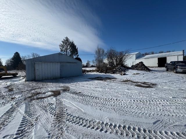 snowy yard with an outbuilding