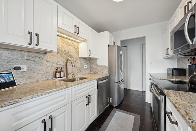 kitchen featuring appliances with stainless steel finishes, dark hardwood / wood-style flooring, sink, and white cabinets