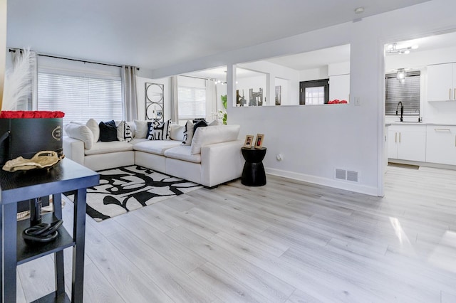 living room with sink and light hardwood / wood-style flooring