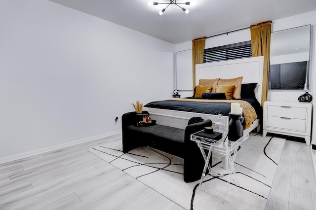 bedroom featuring a chandelier and light hardwood / wood-style flooring