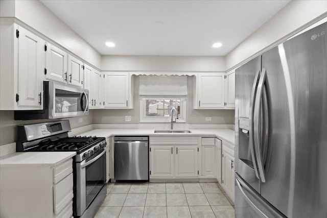 kitchen featuring sink, white cabinetry, light tile patterned floors, and stainless steel appliances