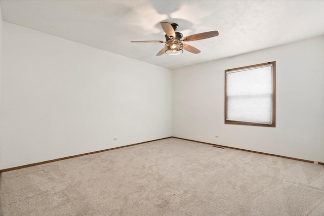 carpeted spare room featuring ceiling fan