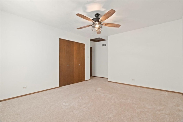 unfurnished bedroom featuring ceiling fan, a closet, and light carpet