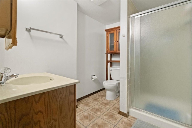 bathroom with toilet, an enclosed shower, and vanity