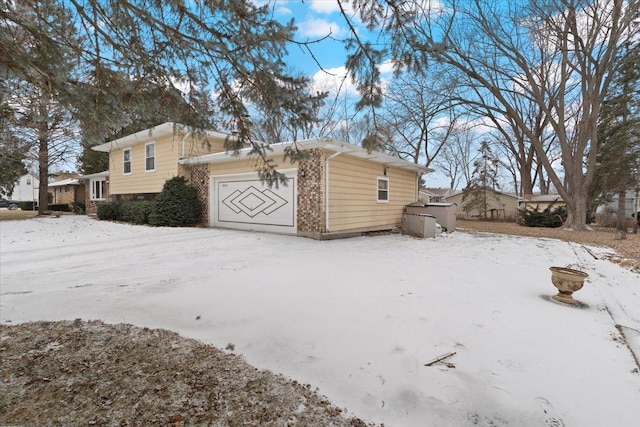 snow covered property with a garage