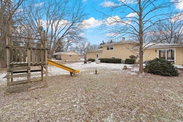 yard layered in snow with a playground