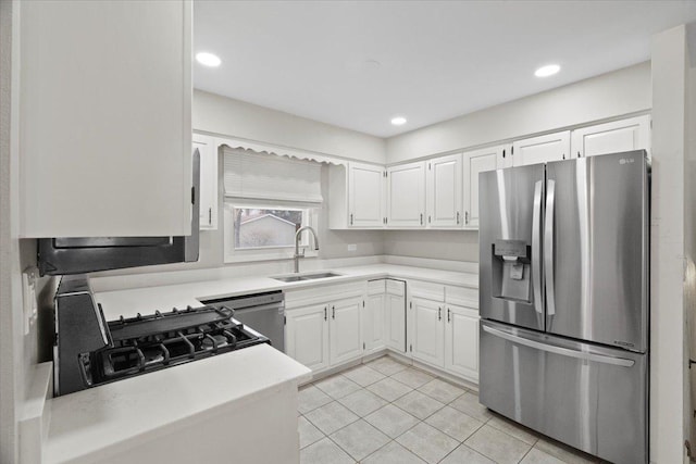 kitchen with sink, white cabinets, stainless steel appliances, and light tile patterned flooring