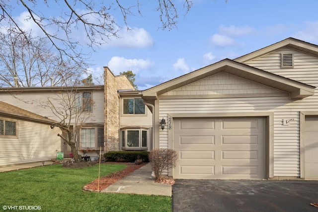 multi unit property with a chimney, driveway, a front lawn, and a garage