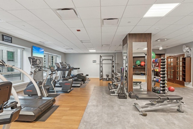 workout area featuring a drop ceiling and hardwood / wood-style flooring