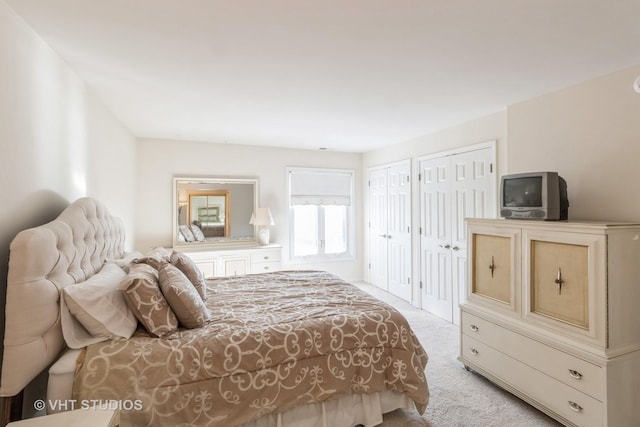 carpeted bedroom featuring two closets