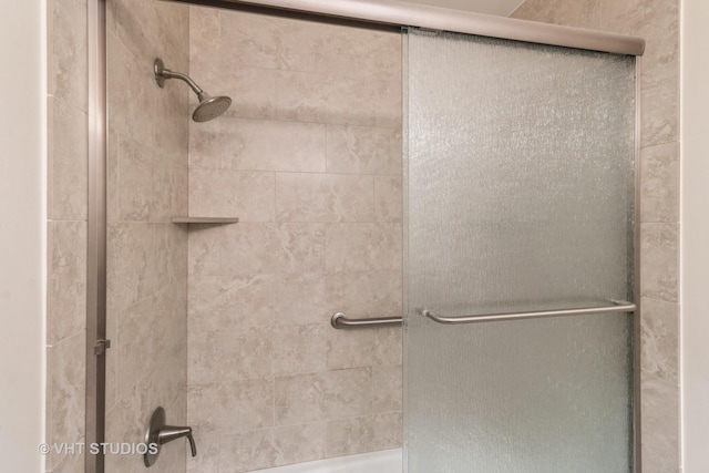 bathroom with a shower with door