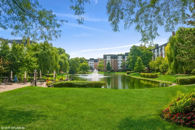 view of home's community featuring a water view and a lawn