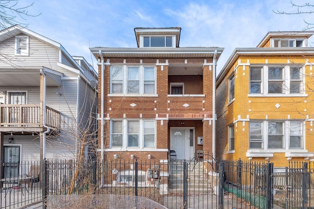 view of front of property with a fenced front yard and brick siding