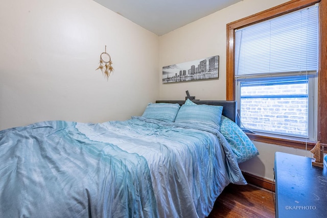 bedroom with wood finished floors and baseboards