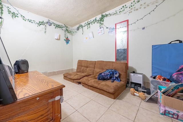 living area with tile patterned flooring and a textured ceiling