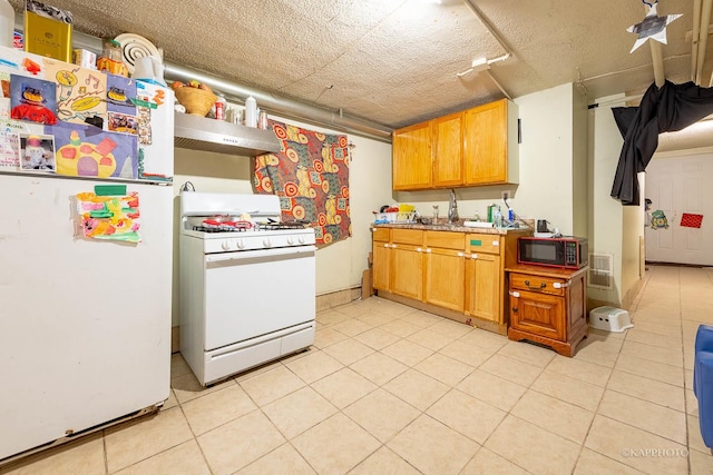 kitchen with light tile patterned floors, white appliances, brown cabinets, and under cabinet range hood