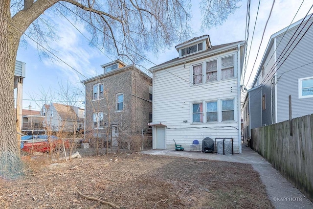 rear view of property featuring fence