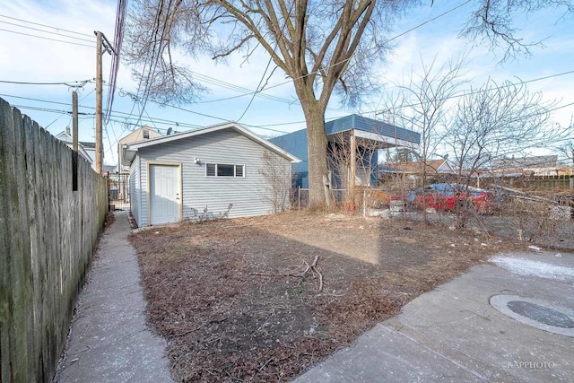 back of property with fence and an outdoor structure