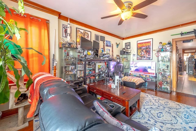 living area featuring ceiling fan, wood finished floors, and crown molding