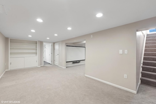 interior space featuring built in shelves and light colored carpet