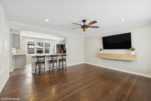 unfurnished living room with dark wood-type flooring, ornamental molding, and ceiling fan