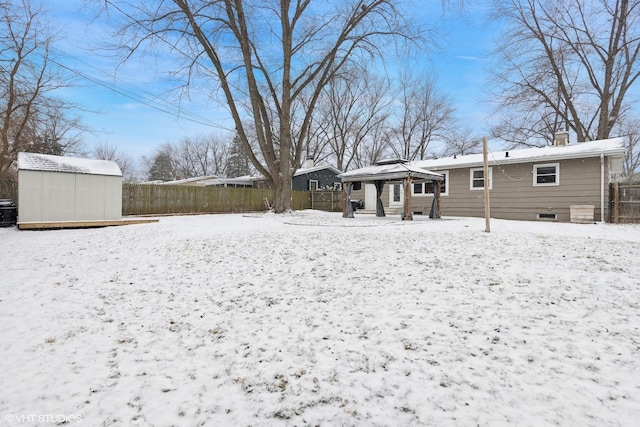 snow covered property featuring a gazebo and a storage unit