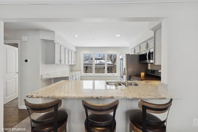 kitchen featuring gray cabinetry, sink, kitchen peninsula, and appliances with stainless steel finishes