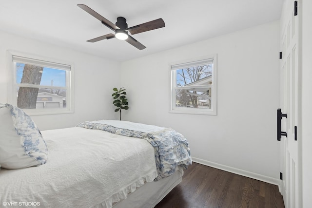 bedroom featuring multiple windows, dark hardwood / wood-style flooring, and ceiling fan