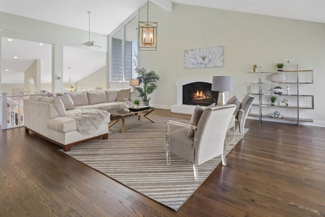 living area featuring vaulted ceiling with beams, recessed lighting, a fireplace, wood finished floors, and baseboards