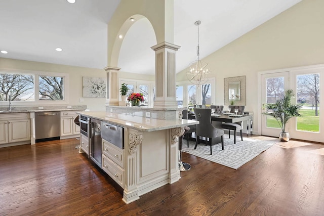 kitchen with dishwasher, light stone counters, dark wood-style flooring, ornate columns, and a warming drawer