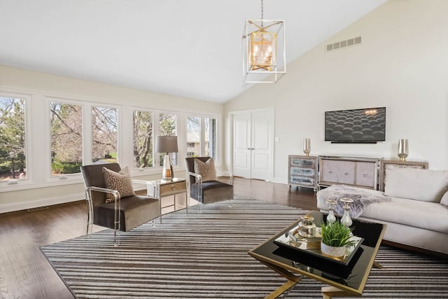 living room with baseboards, visible vents, a chandelier, wood finished floors, and high vaulted ceiling