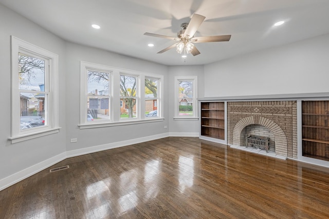 unfurnished living room with ceiling fan, hardwood / wood-style flooring, and a brick fireplace