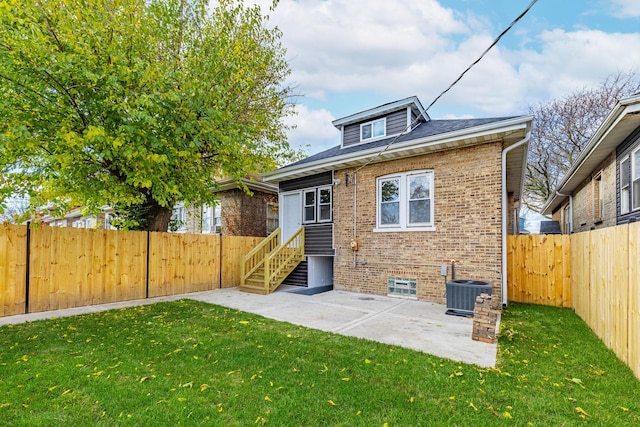 rear view of property with a patio, central air condition unit, and a lawn