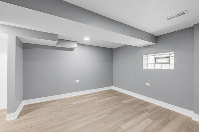 basement with light hardwood / wood-style flooring