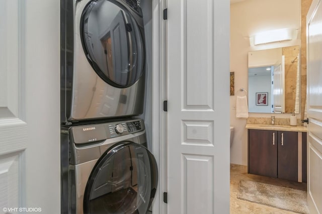 washroom featuring stacked washer / dryer and sink