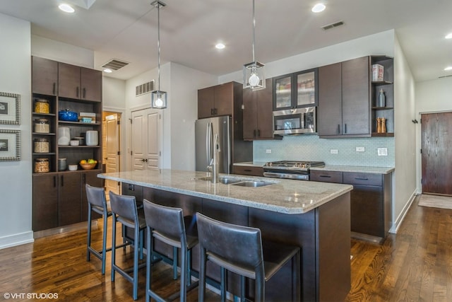 kitchen featuring stainless steel appliances, hanging light fixtures, sink, and dark brown cabinets