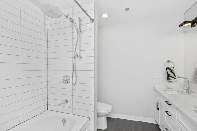 full bathroom featuring vanity, tiled shower / bath, hardwood / wood-style flooring, and toilet