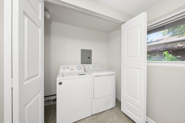 washroom with electric panel, light tile patterned floors, and washing machine and clothes dryer