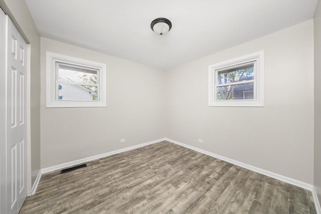 spare room with wood-type flooring and a wealth of natural light