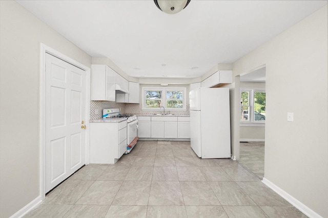 kitchen with sink, backsplash, white appliances, and white cabinets