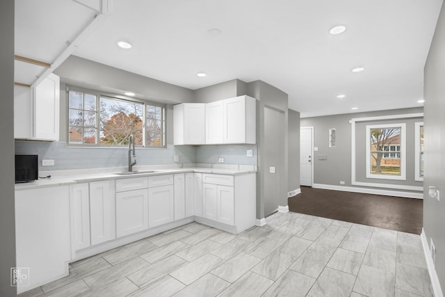 kitchen with sink, white cabinetry, plenty of natural light, and tasteful backsplash